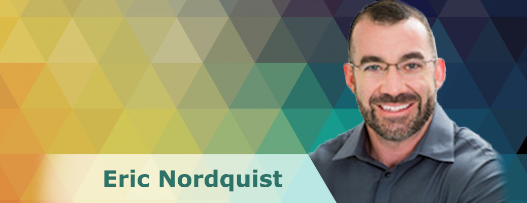 Professor Eric Nordquist in front of a colorful tessellated background