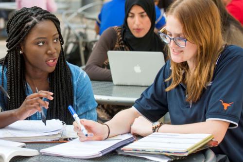 Two female students are discussing and studying