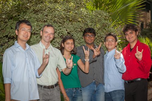 Professor Matt Lease with students of the Information Retrieval Lab making the hookem horns hand sign