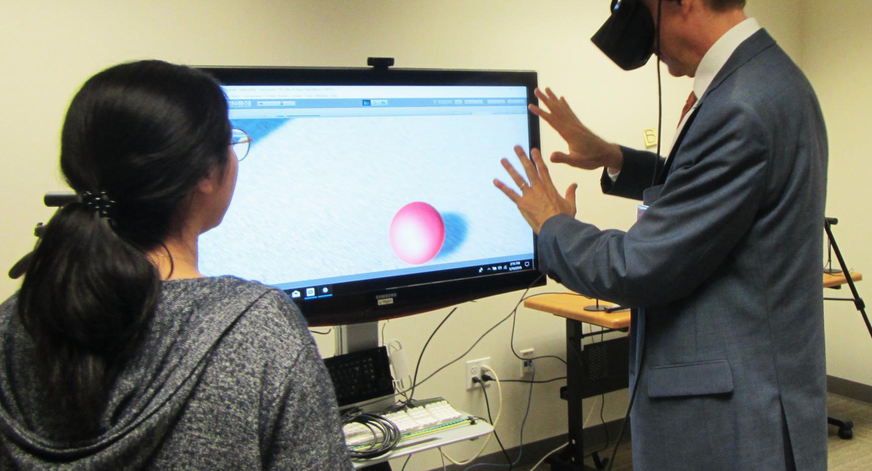 Dean Eric Meyer experiments with a graduate student's virtual reality capstone project