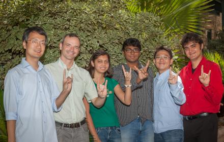 Professor Matt Lease with students of the Information Retrieval Lab making the hookem horns hand sign